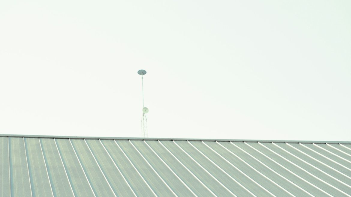 a man riding a skateboard on top of a metal roof