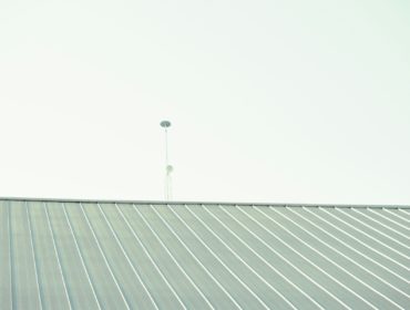 a man riding a skateboard on top of a metal roof